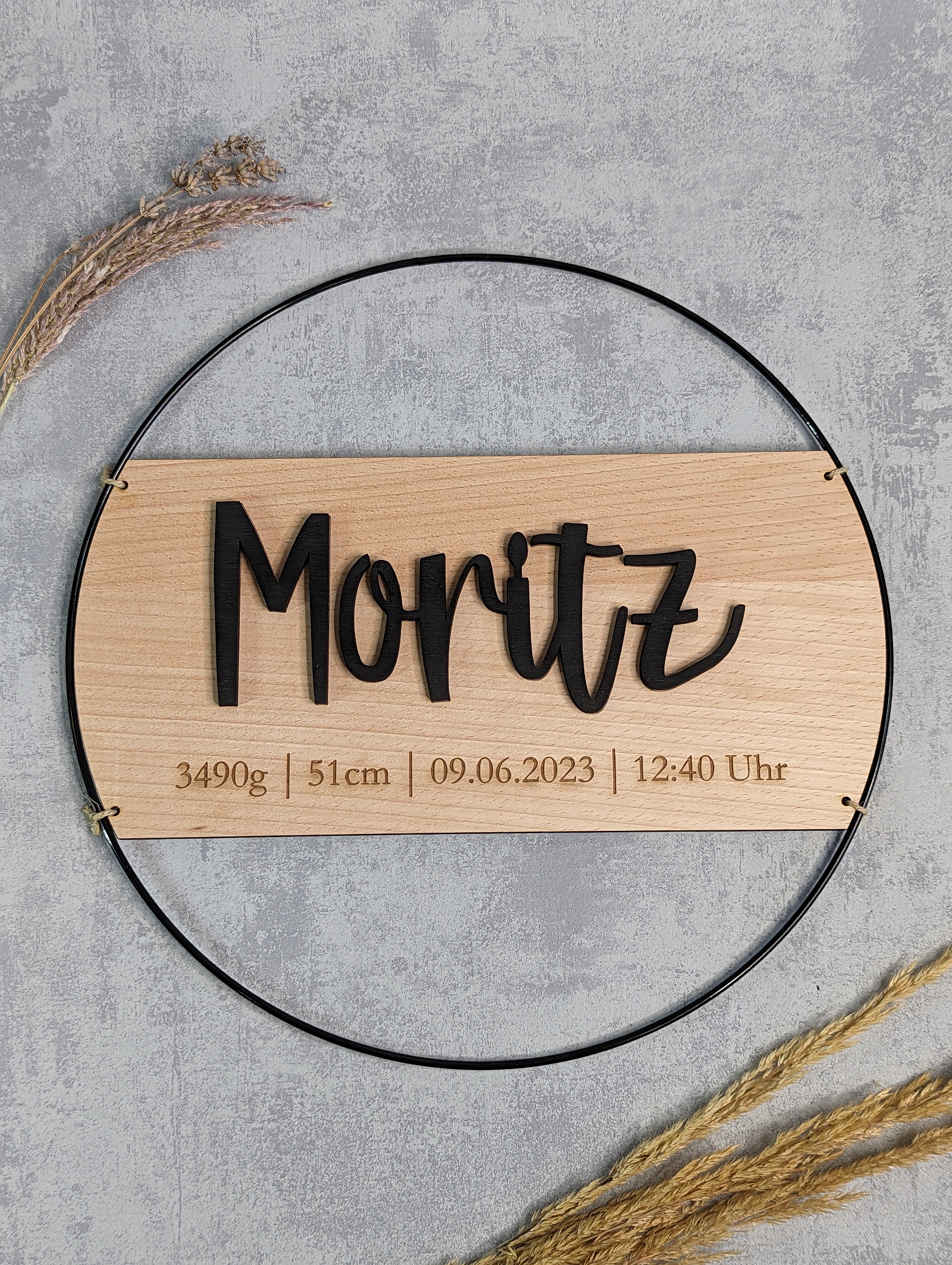 Personalisierter Geburts-Loop aus schwarzem Metallring mit Holzschild, graviert mit Name 'Moritz' und Geburtsdaten, 30cm oder 40cm Durchmesser, handgefertigt als Geschenk zur Geburt oder Taufe