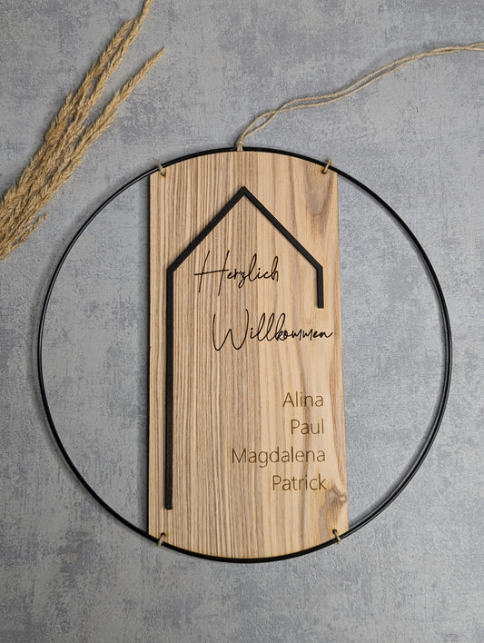Personalisierte Holz-Willkommenstafel mit Familiennamen in einem dekorativen Metallring