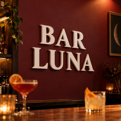 Weiße 3D-Buchstaben BAR LUNA in einer Cocktailbar mit dunkelroter Wand – Gestaltungsbeispiel