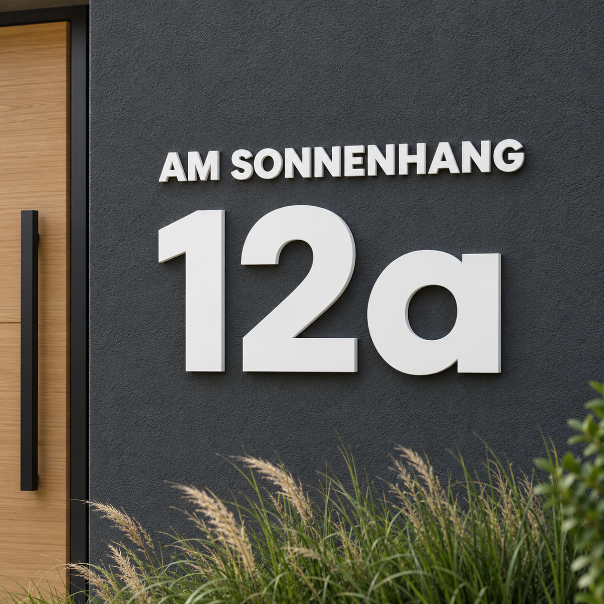 Weiße 3D-Hausnummer 12a mit kleinem Straßennamen AM SONNENHANG auf dunkler Fassade – Gestaltungsbeispiel aus zwei Konfigurationen