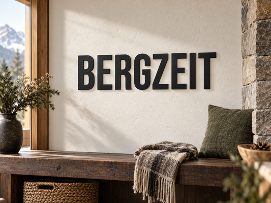 3D-Schriftzug BERGZEIT in Schwarz aus PLA, Schrift Bebas Neue, als Wanddekoration im passend eingerichteten Wohnraum