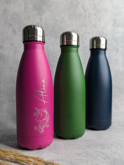 Personalisierte Edelstahl-Thermoflaschen in Pink, Grün und Dunkelblau mit silbernem Schraubdeckel. Die pinke Flasche trägt eine Gravur mit dem Namen 'Alina' und einem Einhorn-Motiv. Ideal als nachhaltige, doppelwandige Trinkflasche für heiße und kalte Getränke. Hochwertige Gravur für individuelle Geschenke oder den täglichen Gebrauch.