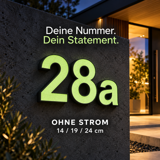 Fluoreszierende Hausnummer 28a mit schwarzem Rahmen und grün nachleuchtender Front am modernen Hauseingang – ohne Strom, in 14, 19 und 24 cm. Produktvisualisierung.