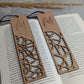 Zwei personalisierte Holz-Lesezeichen mit filigranen Mustern und den eingravierten Namen 'Magdalena' und 'Marion'. Die Lesezeichen liegen auf einem geöffneten Buch und sind mit einer braunen Kordel versehen.
